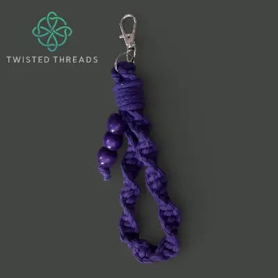 Purple braided keychain with metal clip on a dark gray background