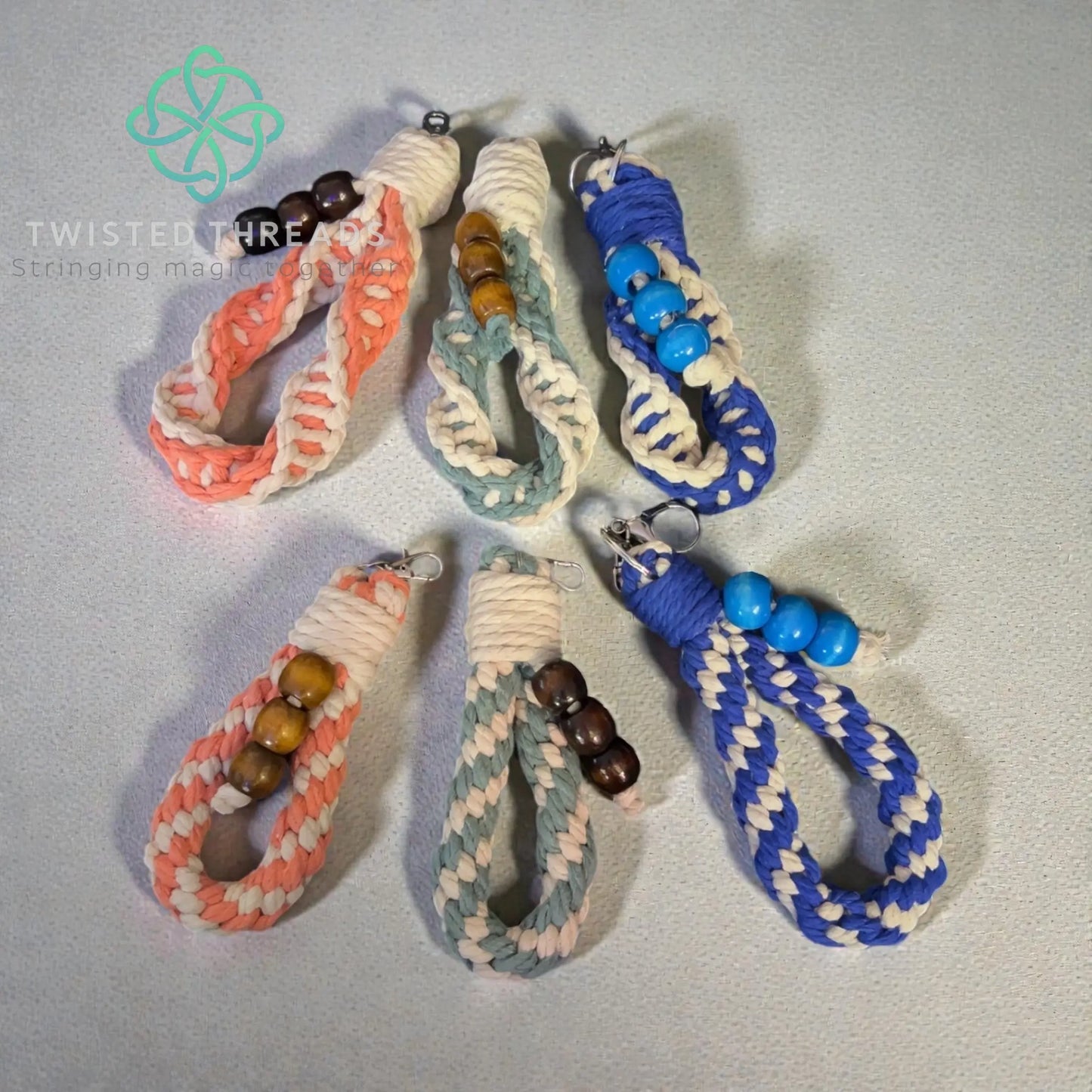 Set of braided keychains with beads on a light gray background