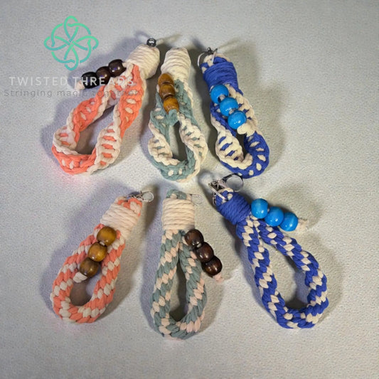 Set of braided keychains with beads on a light gray background