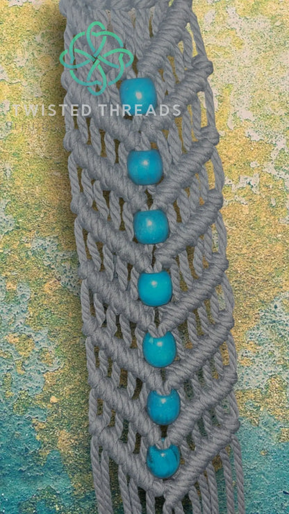 White V-shaped macrame plant hanger with beads by Twisted Threads Au, designed for hanging small to medium plants.