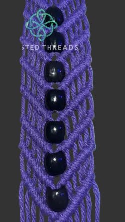 White macrame plant hanger with a V shape and beads by Twisted Threads Au, showcasing intricate knot details for stylish plant display.